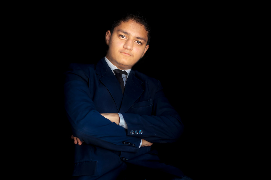 Confident male CEO/entrepreneur/businessman posing on black background.